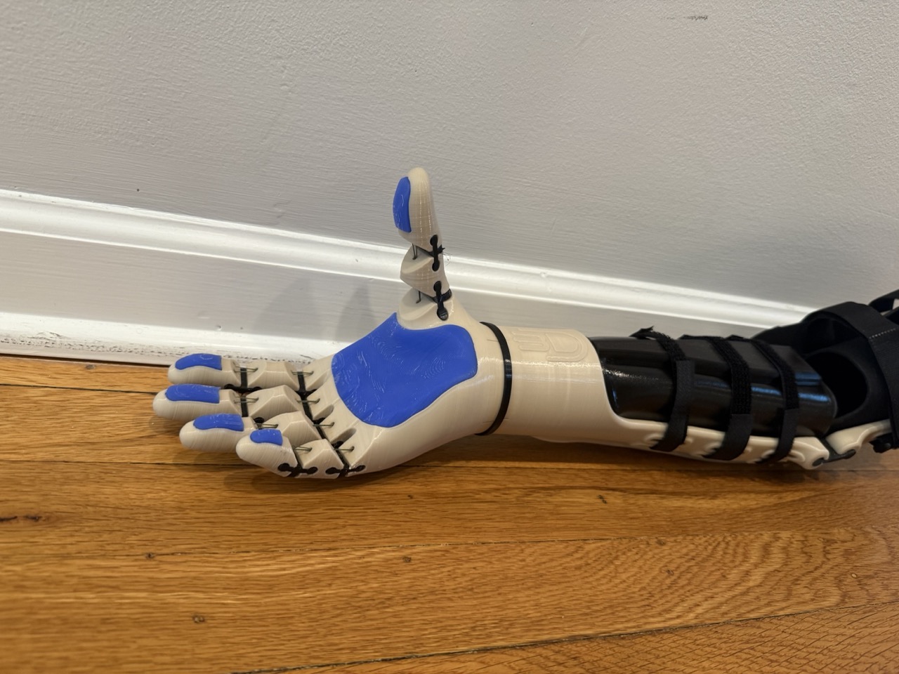 Hand close-up from the side, thumb raised, finger joints visible