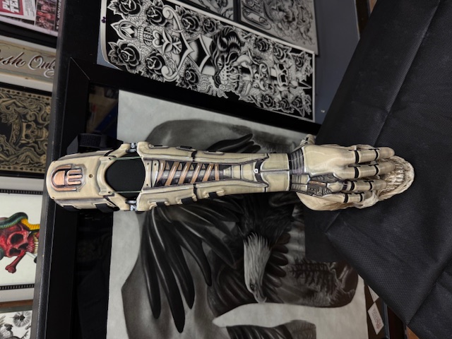 The airbrushed arm standing at the tattoo studio, mechanical skeleton artwork painted on cream PLA+