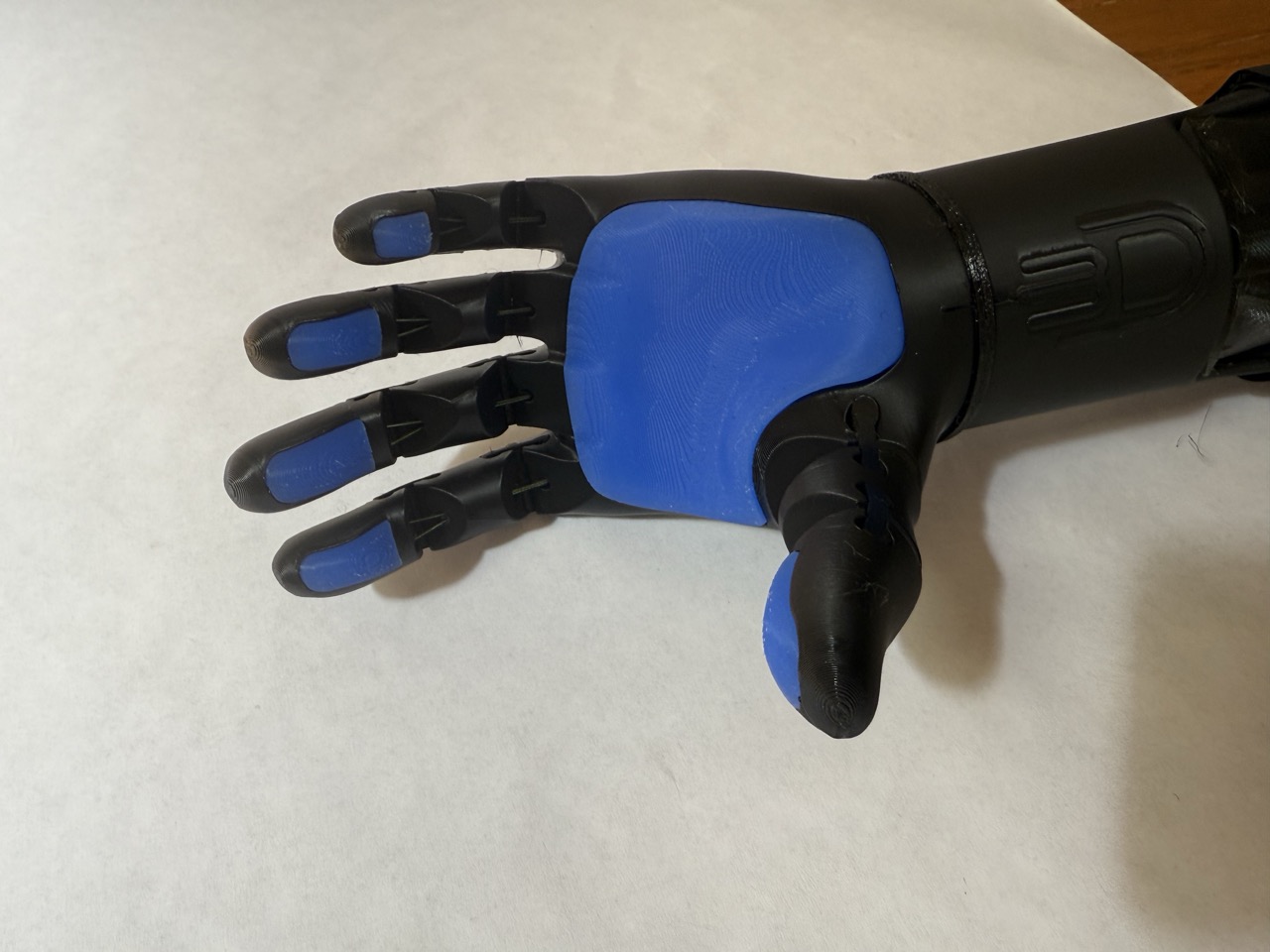 Close-up of the palm showing the textured blue TPU grip pads across all five fingers