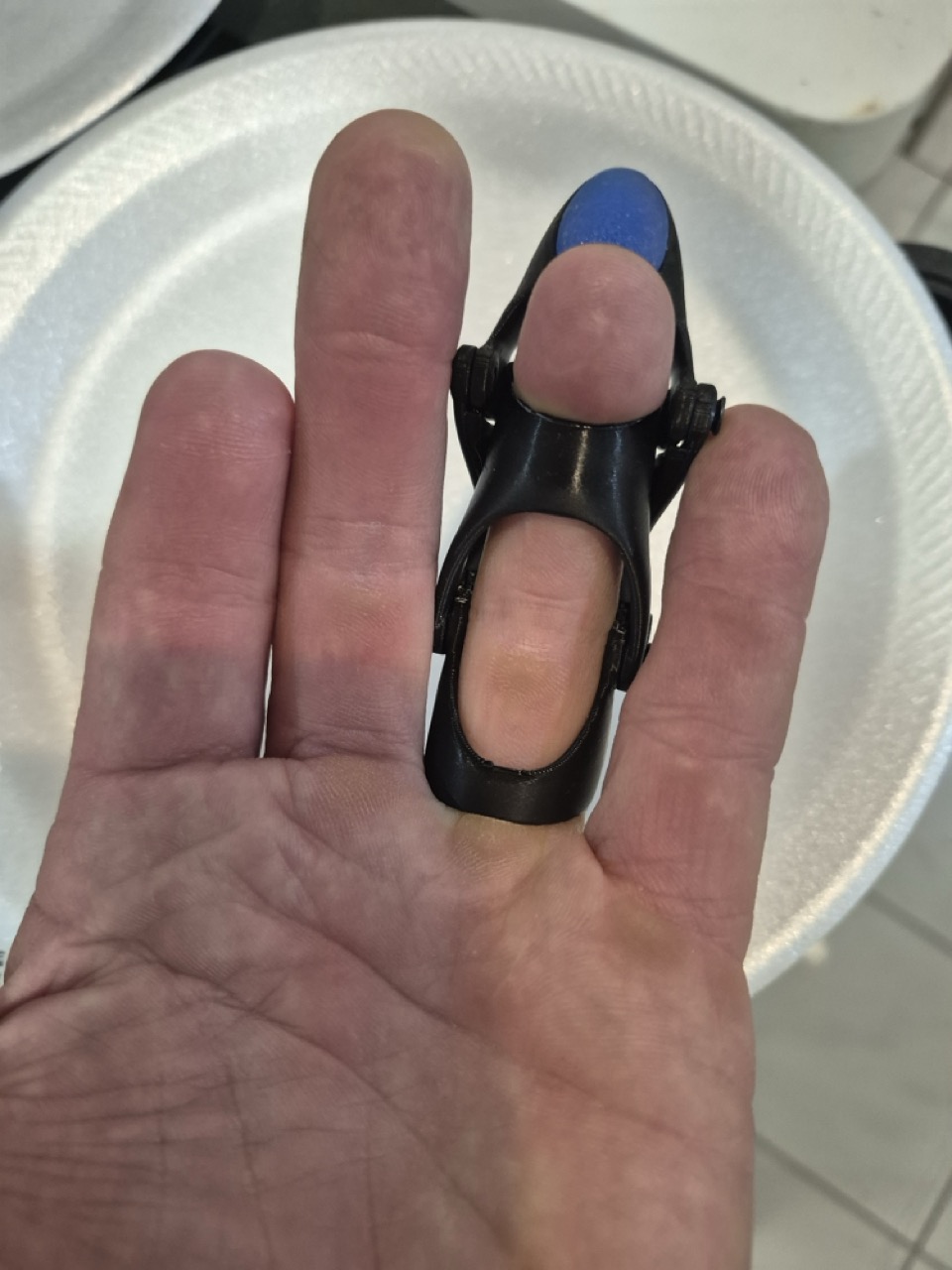 Back of S.P.'s hand wearing the black prototype, showing the retention clip