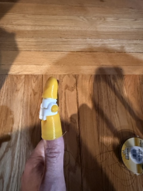 First prototype, yellow kinetic finger on a wood floor, the earliest iteration