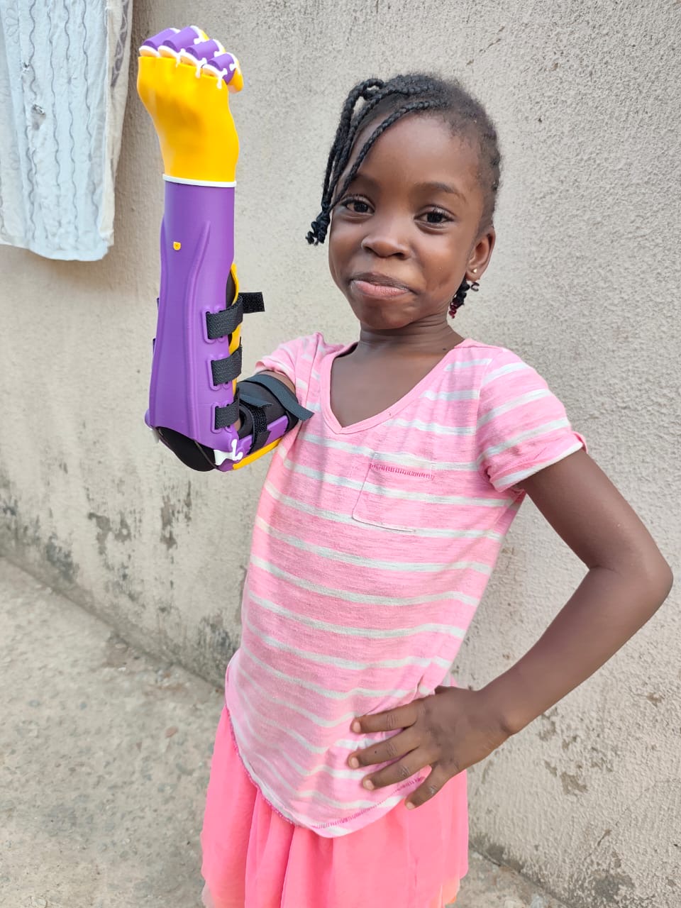 O.C. raising the purple and yellow arm confidently, hand on hip, smiling