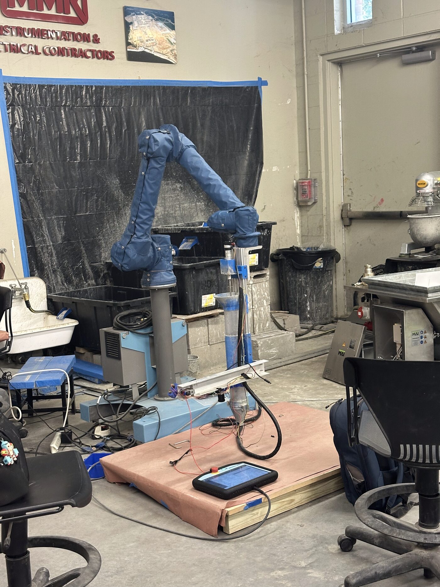 The Universal Robots UR10e robotic arm in the RECAST Lab at LSU, with blue protective covers, positioned over the print area