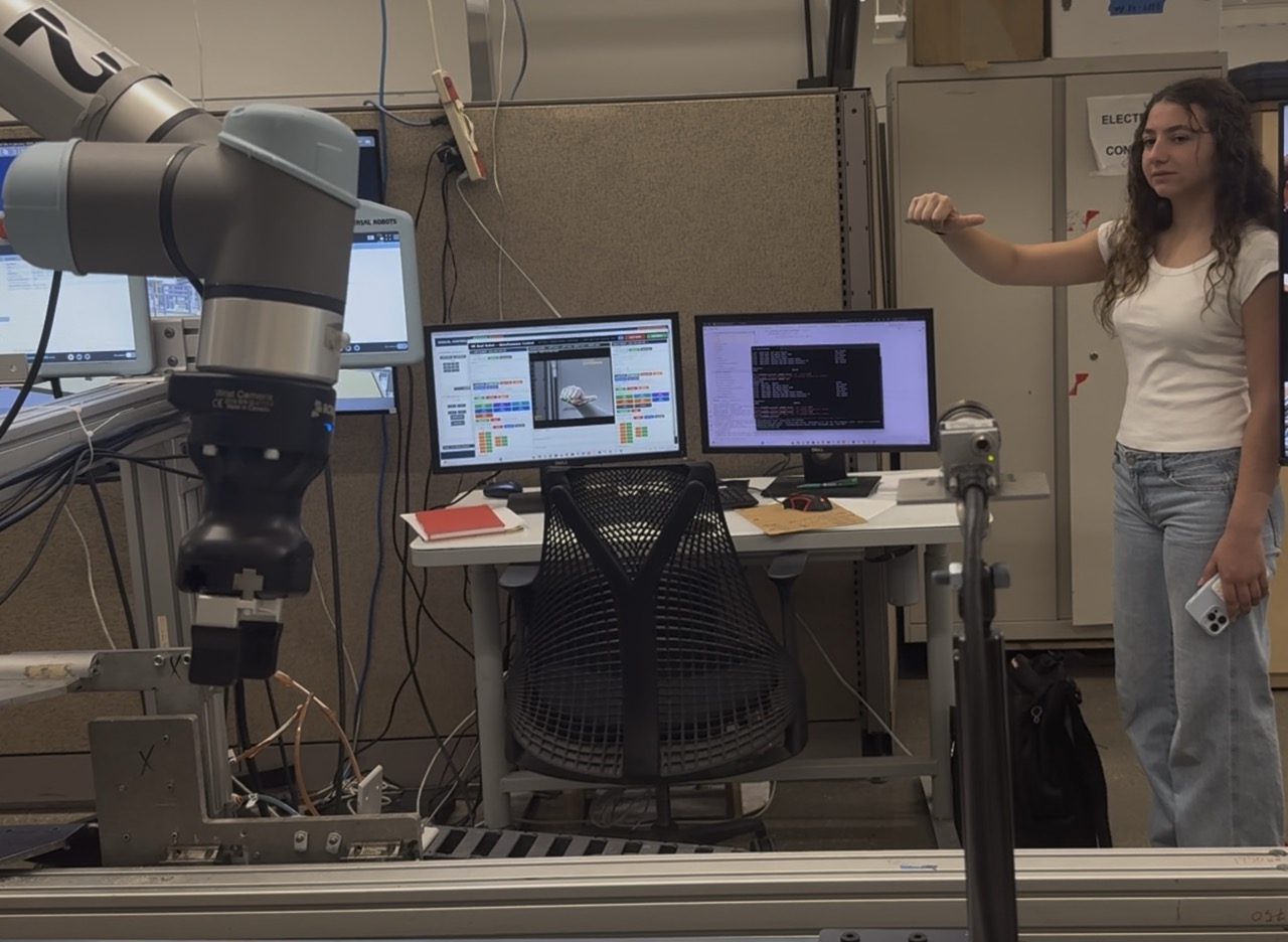 Laila trying the gesture-control system for the robot arm during a lab demo at the University of Alberta
