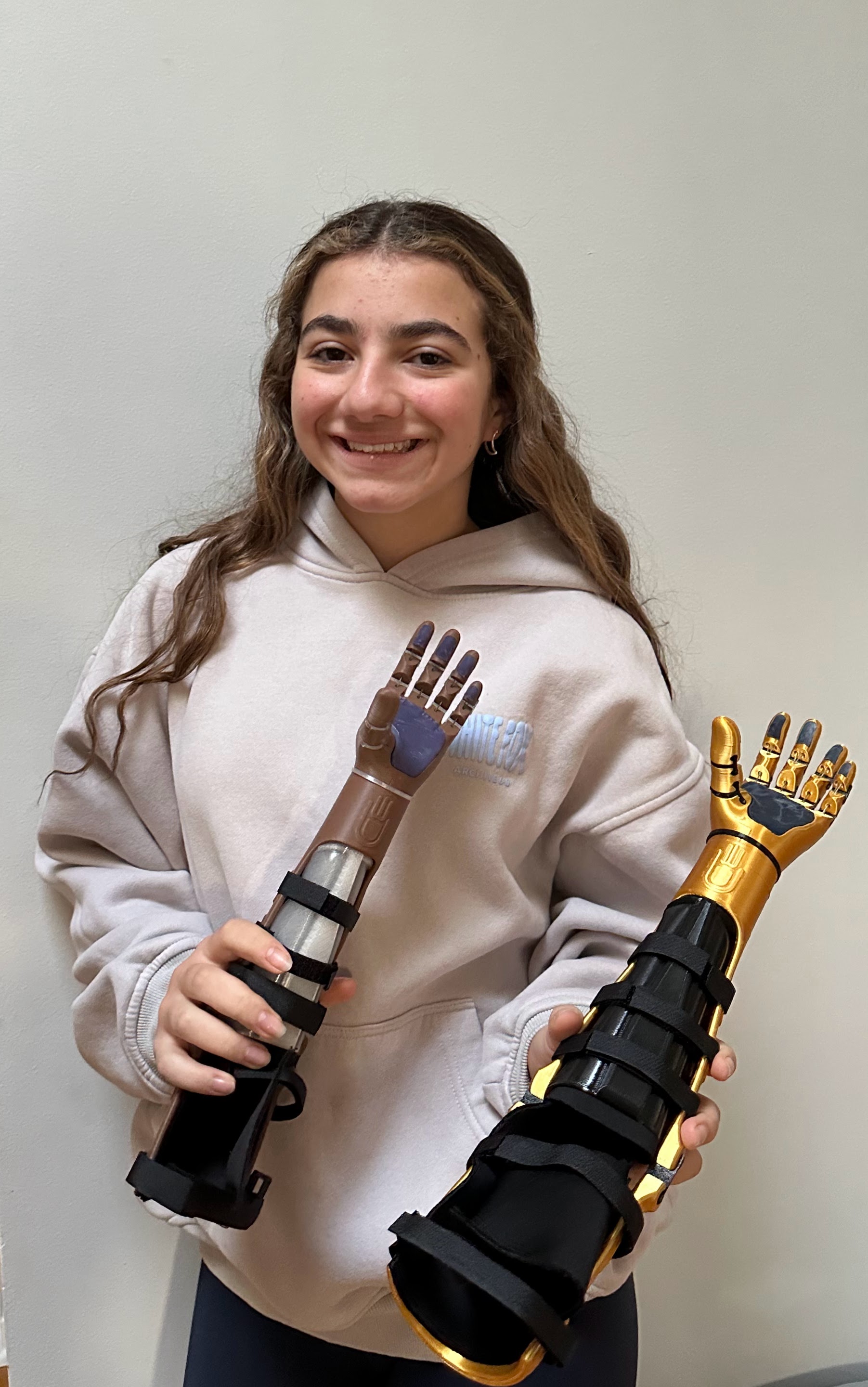 Laila holding two 3D-printed prosthetic arms